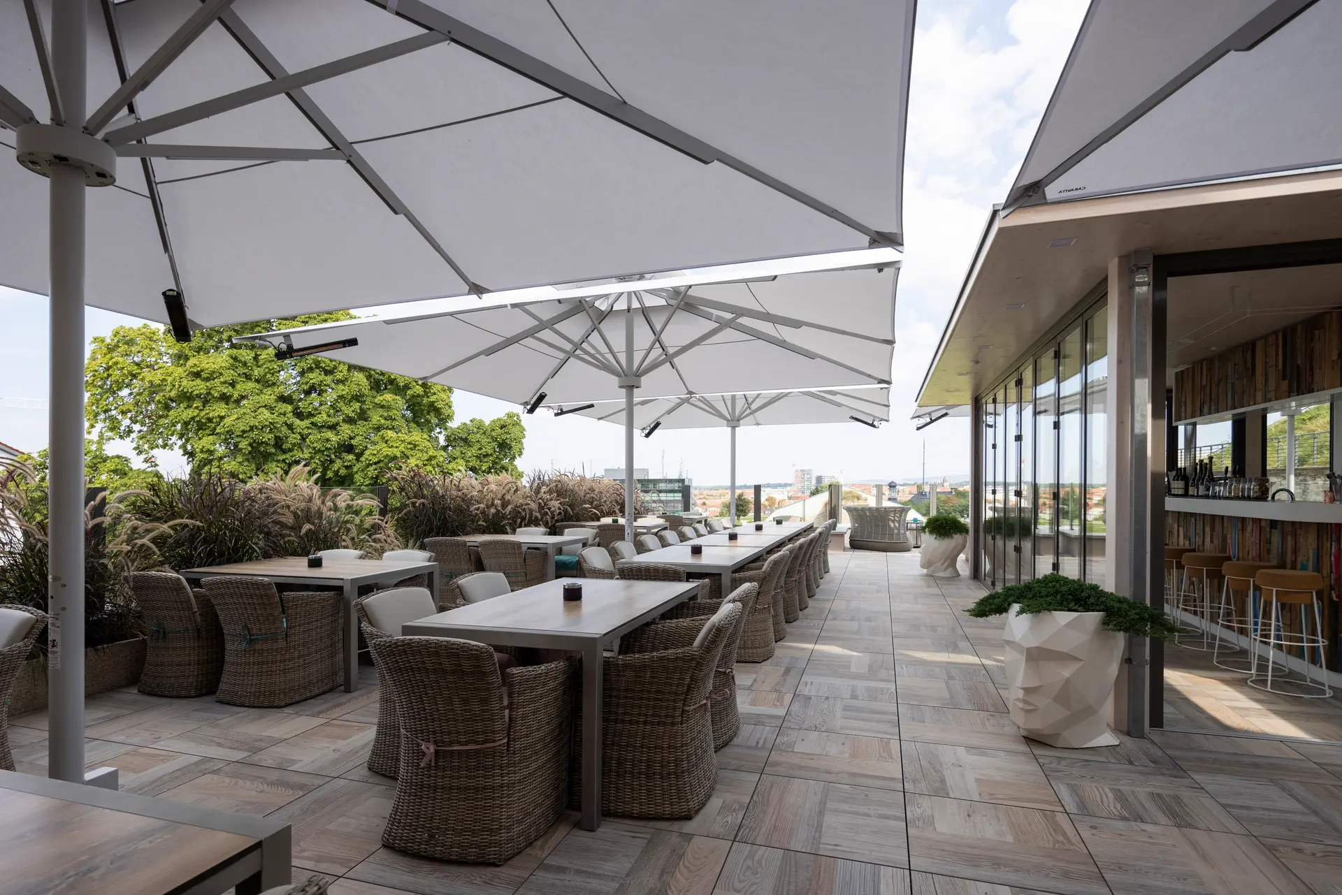 Mehrere weiße große Sonnenschirme zur Abschattung eines Außenbereichs eines Restaurants