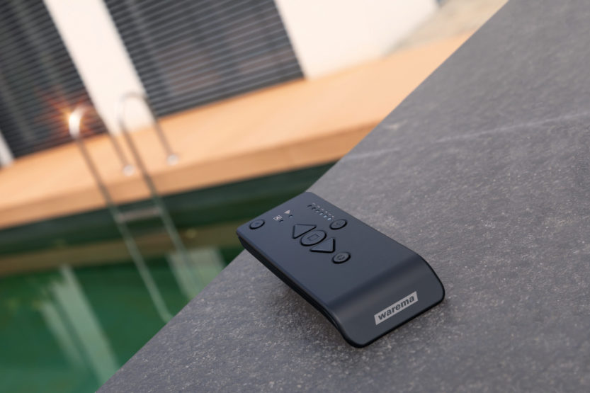 Warema Sonnenschutz Fernsteuerung auf einem Vorsprung vor einem Pool.