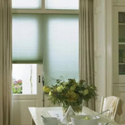 Grün-transparente Wabenplissees in einem Esszimmer.