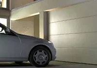 Ein silbernes Auto steht vor einer Garage mit einem weißen Sectionaltor.